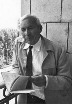 Photograph of Andrey Kolmogorov seated outdoors holding an open notebook.